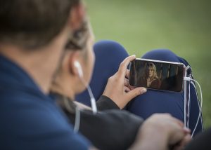 Ragazza che sta guardando un film con lo smartphone.