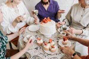 Group of women around a table drinking coffee.